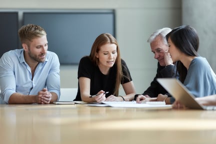 A group of employees review cybersecurity policies in a conference room. 