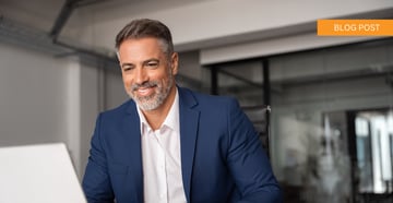 A mature business man using a laptop in a corporate setting. 