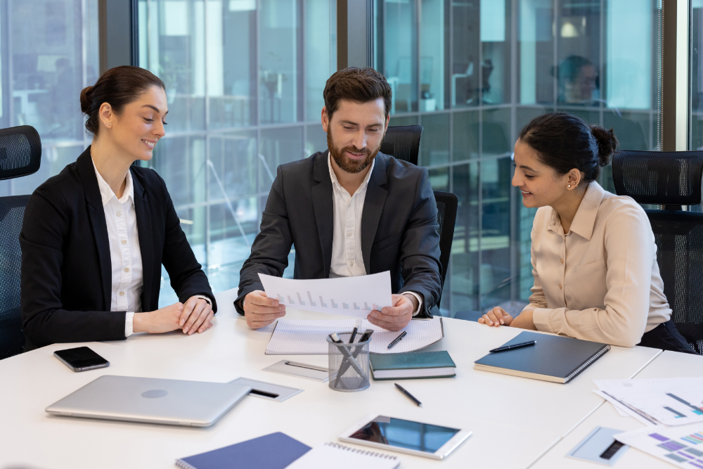 A group of employees meet to review MSP contracts.