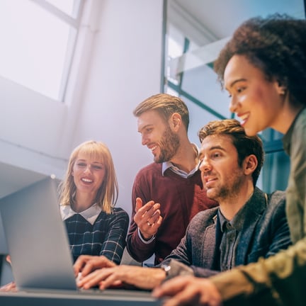 Managed IT support specialist reviewing data with clients on a laptop, providing expert service consultation.