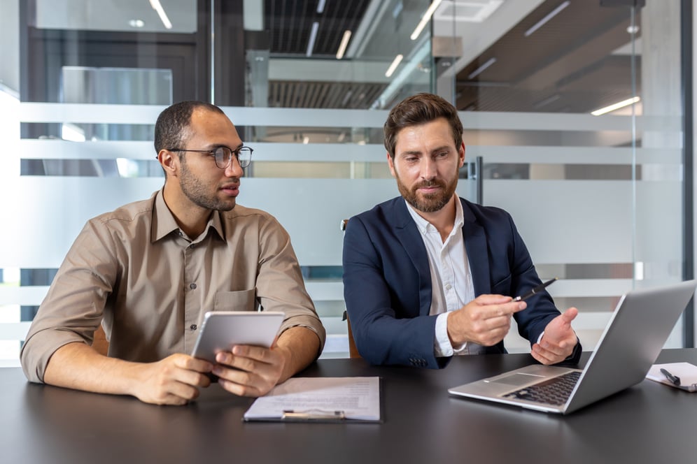 Two employees meeting in an office to discuss IT budget.