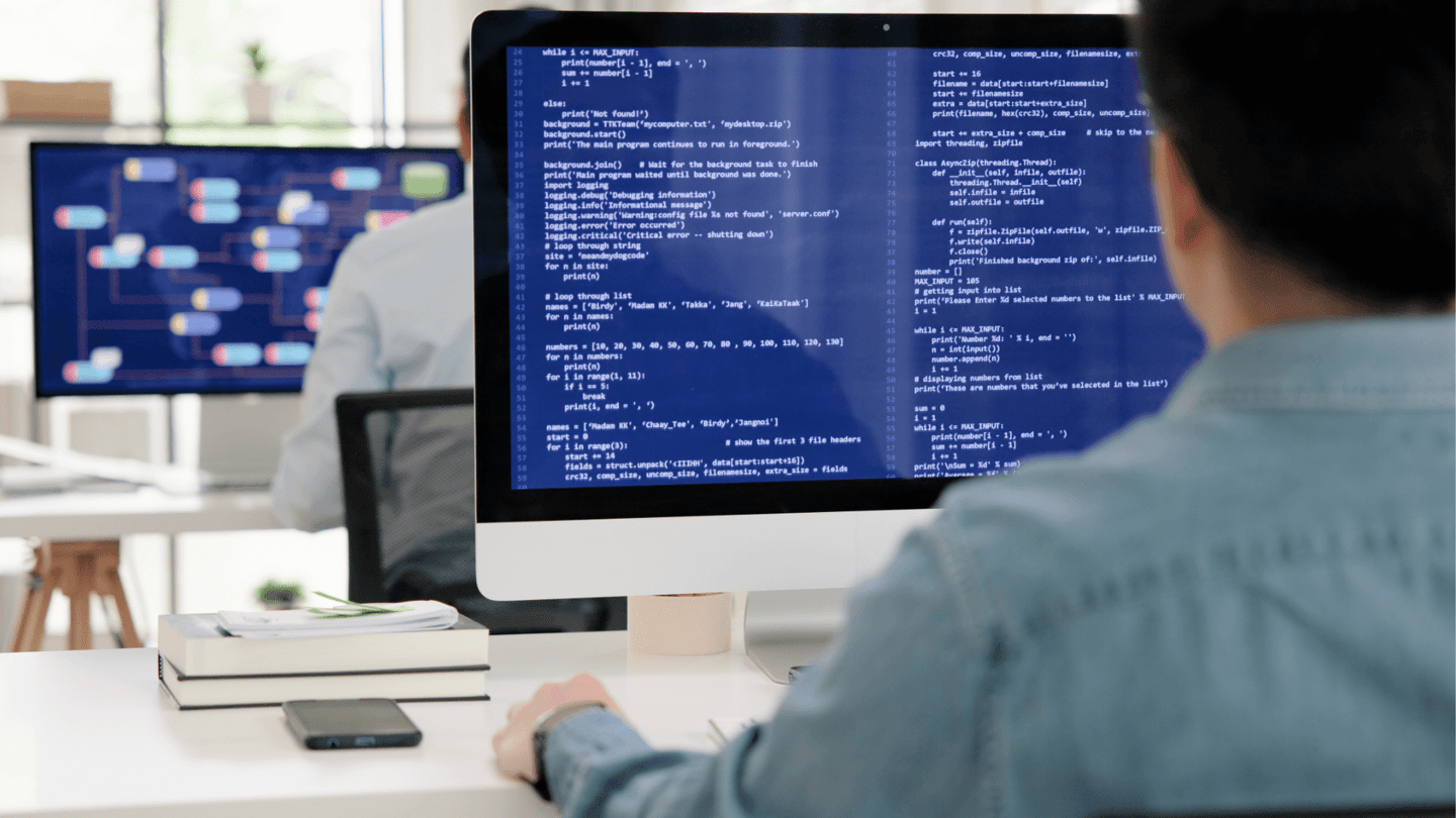 A developer using AI to enhance his code on a computer at work.