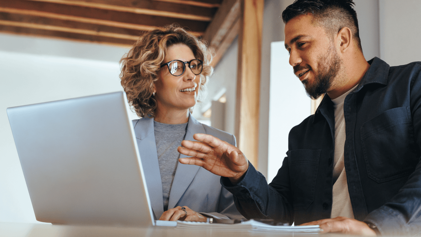 An employee explaining the business use cases for AI to his manager while in an office.