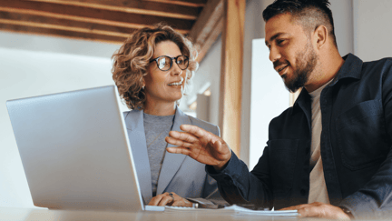 An employee explaining the business use cases for AI to his manager while in an office.