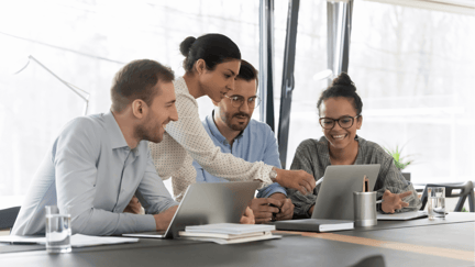 A group of employees discuss options for AI tools while sitting in an office.