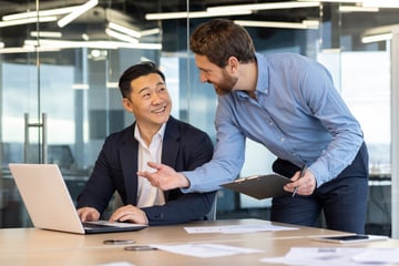 Two male colleagues working in a modern office setting. 