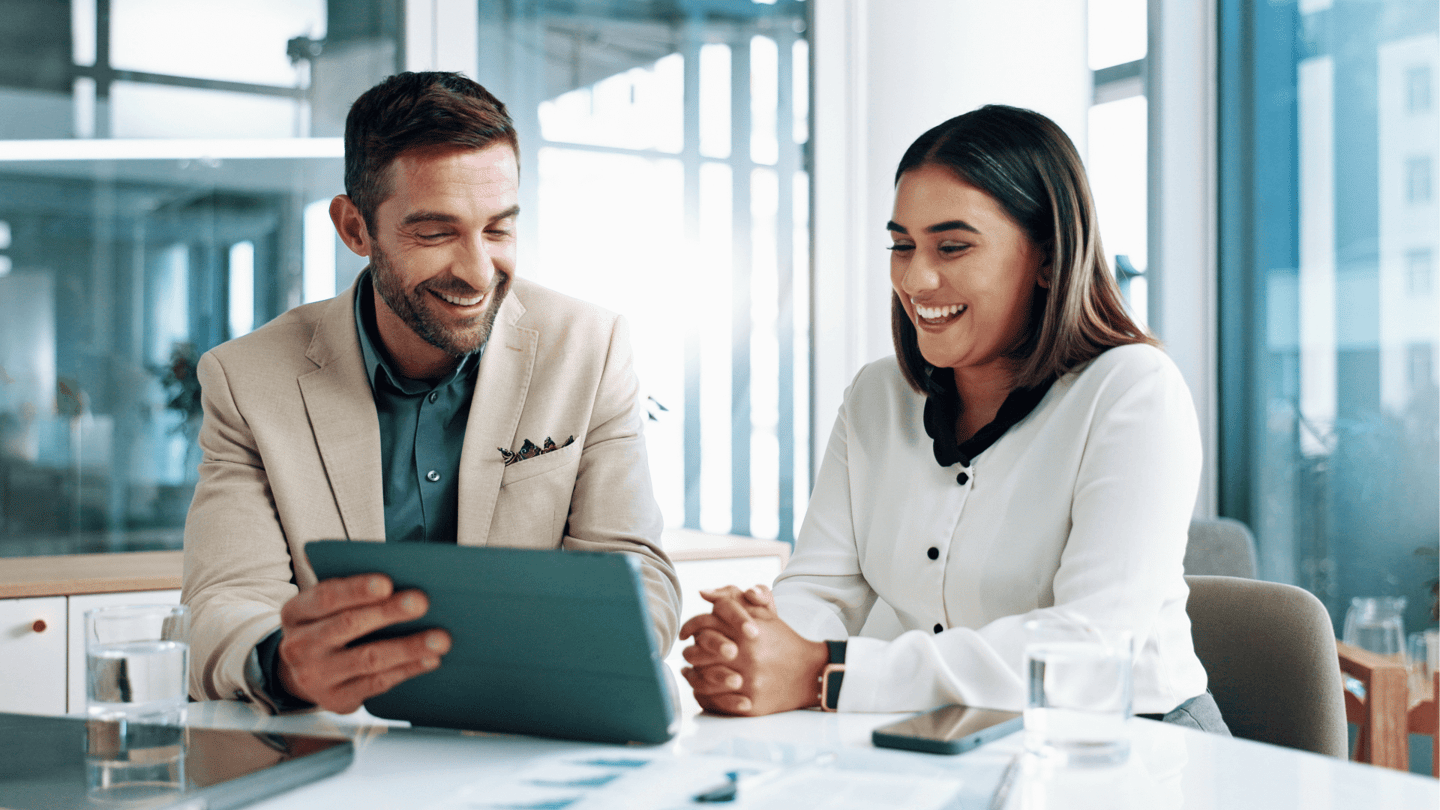 Two employees review IT cost optimization recommendations on an iPad.