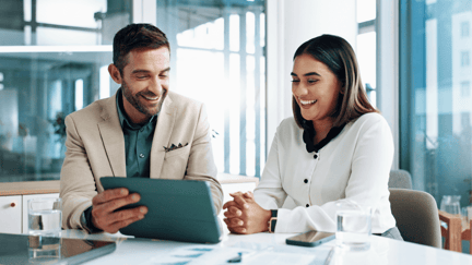 Two employees review IT cost optimization recommendations on an iPad.