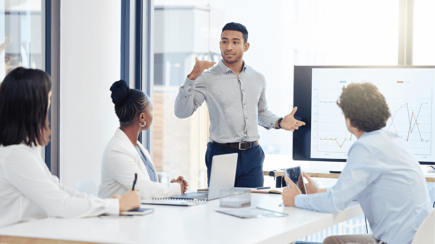 A CFO reviews data on IT cost with a few executives in an office.