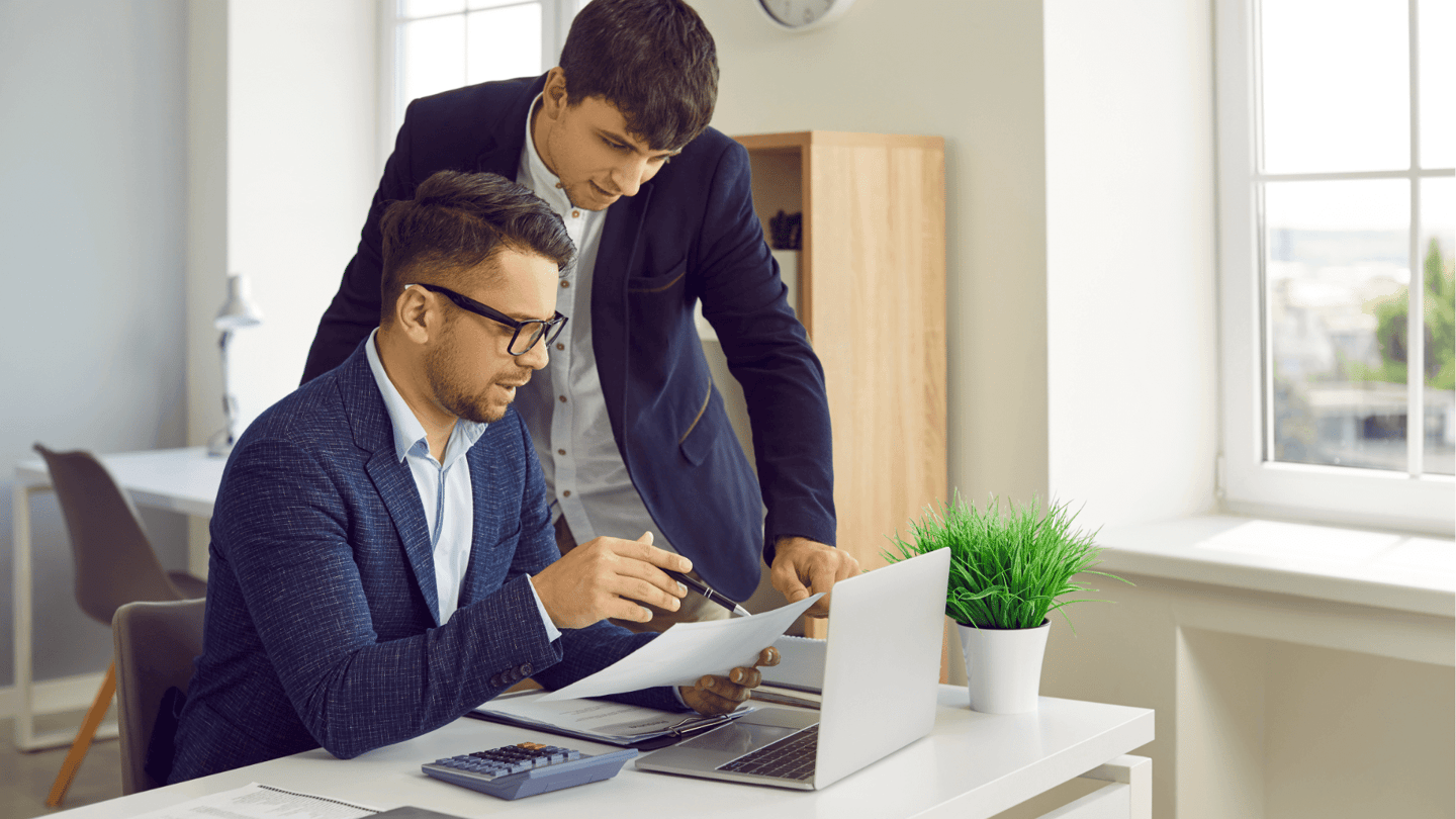 A CFO reviews the IT budget for his organization with an employee.