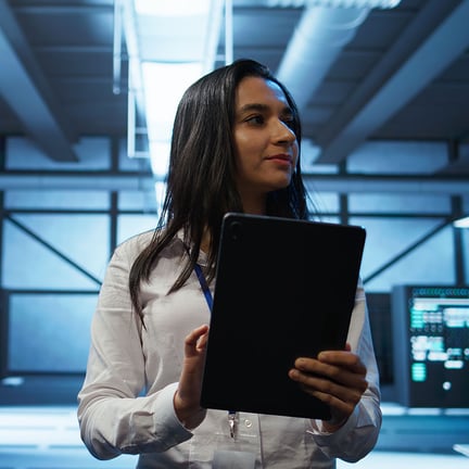 Admin in data center performing network monitoring security threats with tablet