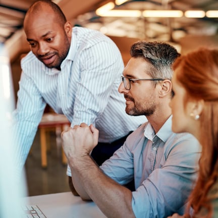 group of professionals seated at desktop discussing strategy