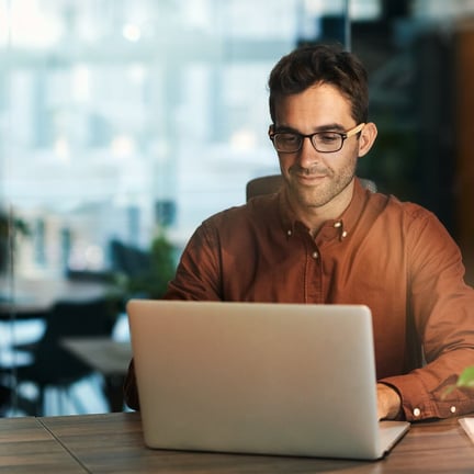 business professional seated at laptop working in well-lit cafe
