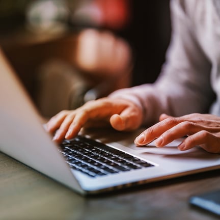 Close up of hands typing on a laptop