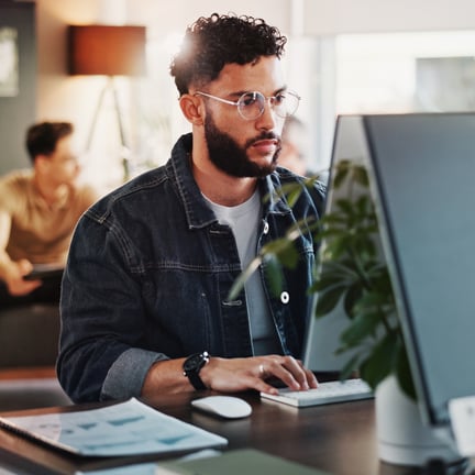 programmer seated at desktop computer with hands on keyboard software engineering