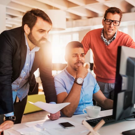 Diverse group of young colleagues working on the computer together in the office