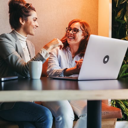 smiling colleagues seated together discussing in a coworking office