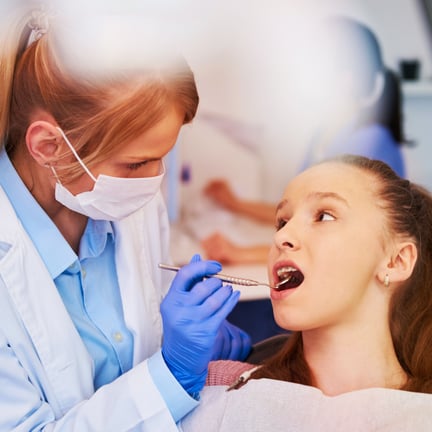 Female orthodontist examining childs teeth