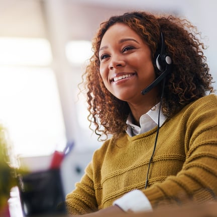 smiling call center agent wearing headset speaking with IT help desk