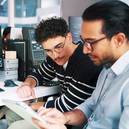 Managed IT services consultant guiding a client through technical data on a tablet for business IT solutions.