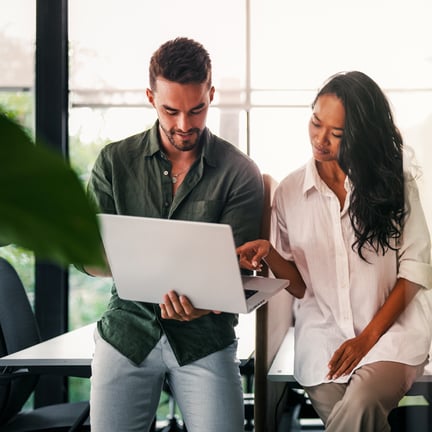 colleagues collaborating on laptop working together on project