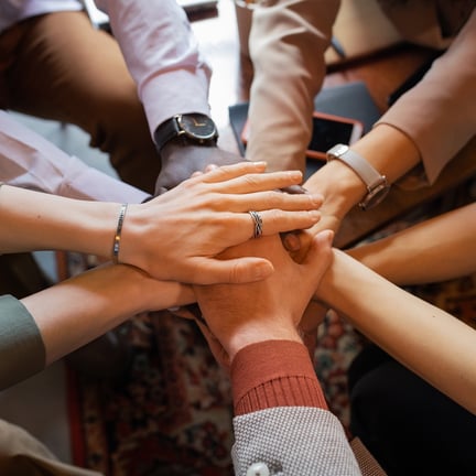 Pile of hands of colleagues symbolizing teamwork and support
