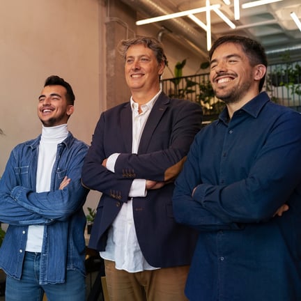 Smiling business team posing with crossed arms in coworking space