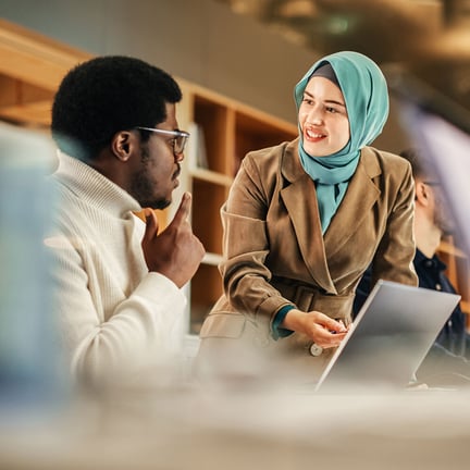 Managed IT services consultant providing technical analysis and expert guidance to a business professional using a laptop.