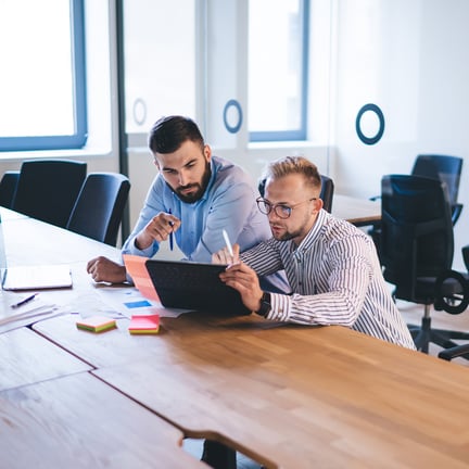 pair of IT consultants working together on tablet device in a modern office