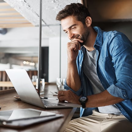 smiling IT consultant working in a modern office on laptop