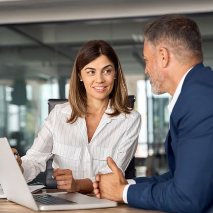 Businessman and businesswoman discussing a project on a laptop in the office