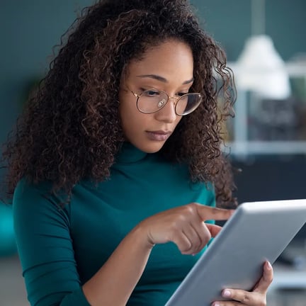 A woman using her digital tablet while standing in the office