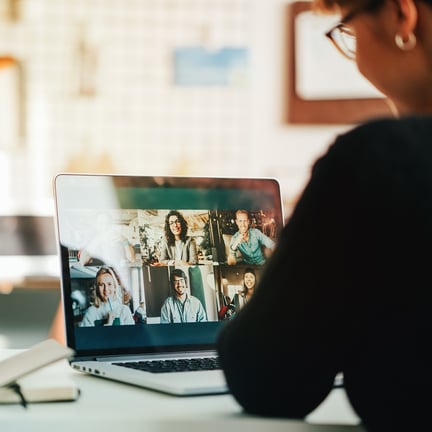 A person views a six-person video conference call on their laptop